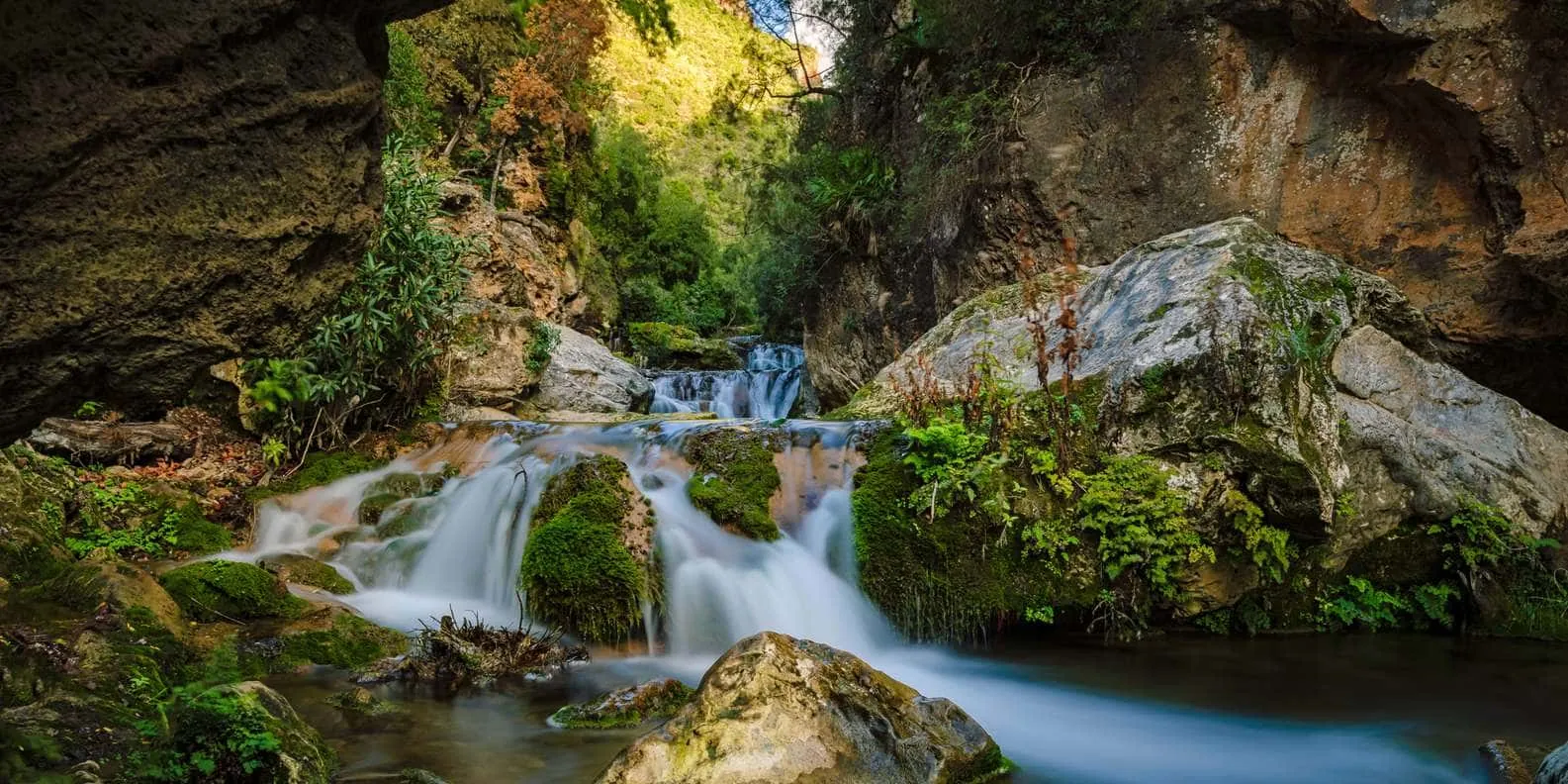 A long-exposure cascade flowing over mossy rocks in a Rif gorge.